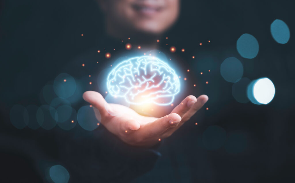 Une main ouverte sous un cerveau lumineux