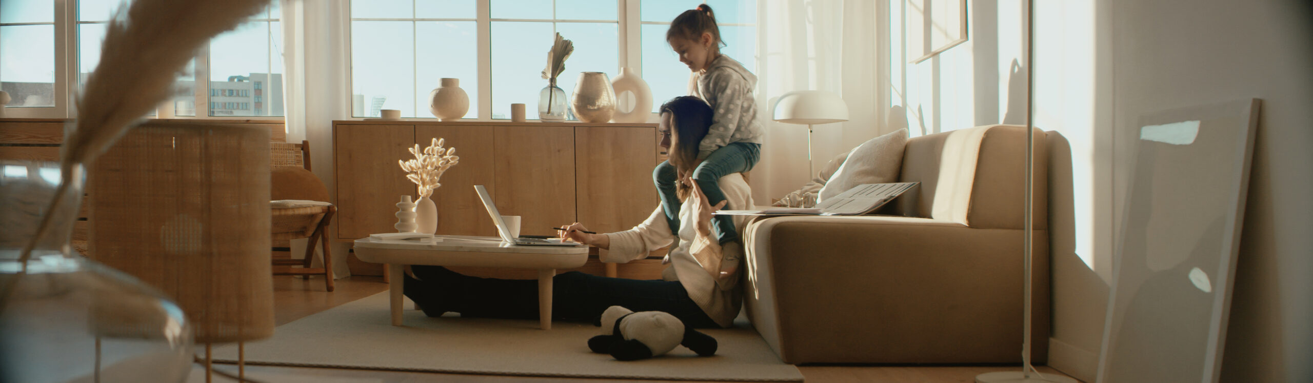 A mother working from her living room, her daughter on her shoulders